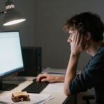 Personne confuse devant un écran d'ordinateur vide.